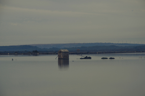 A little cabin standing alone in the middle of a lake