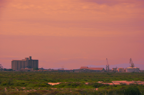 A factory seen from afar, the sky is red